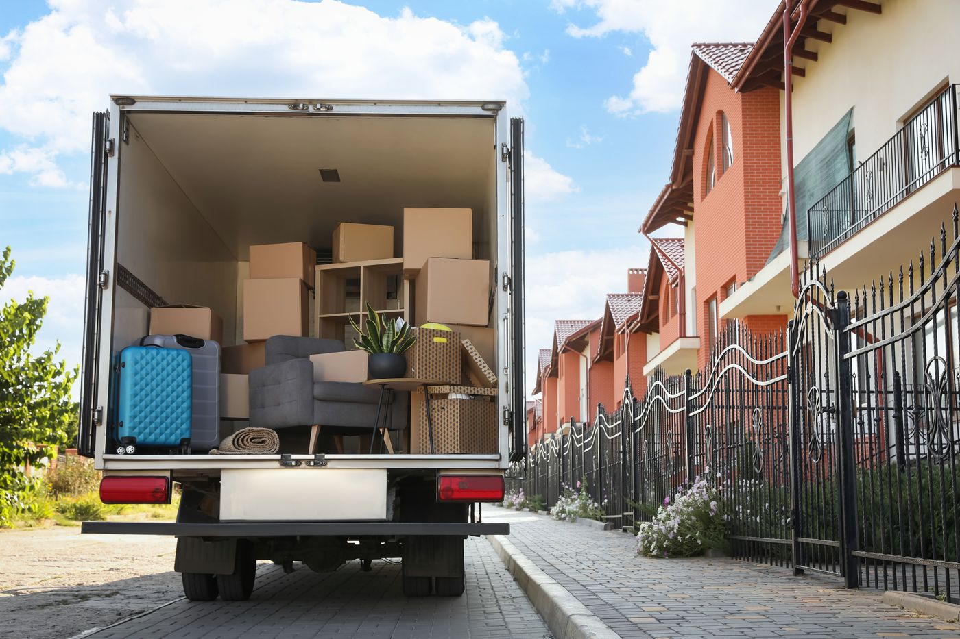 Loaded junk removal box truck parked at a residential job site