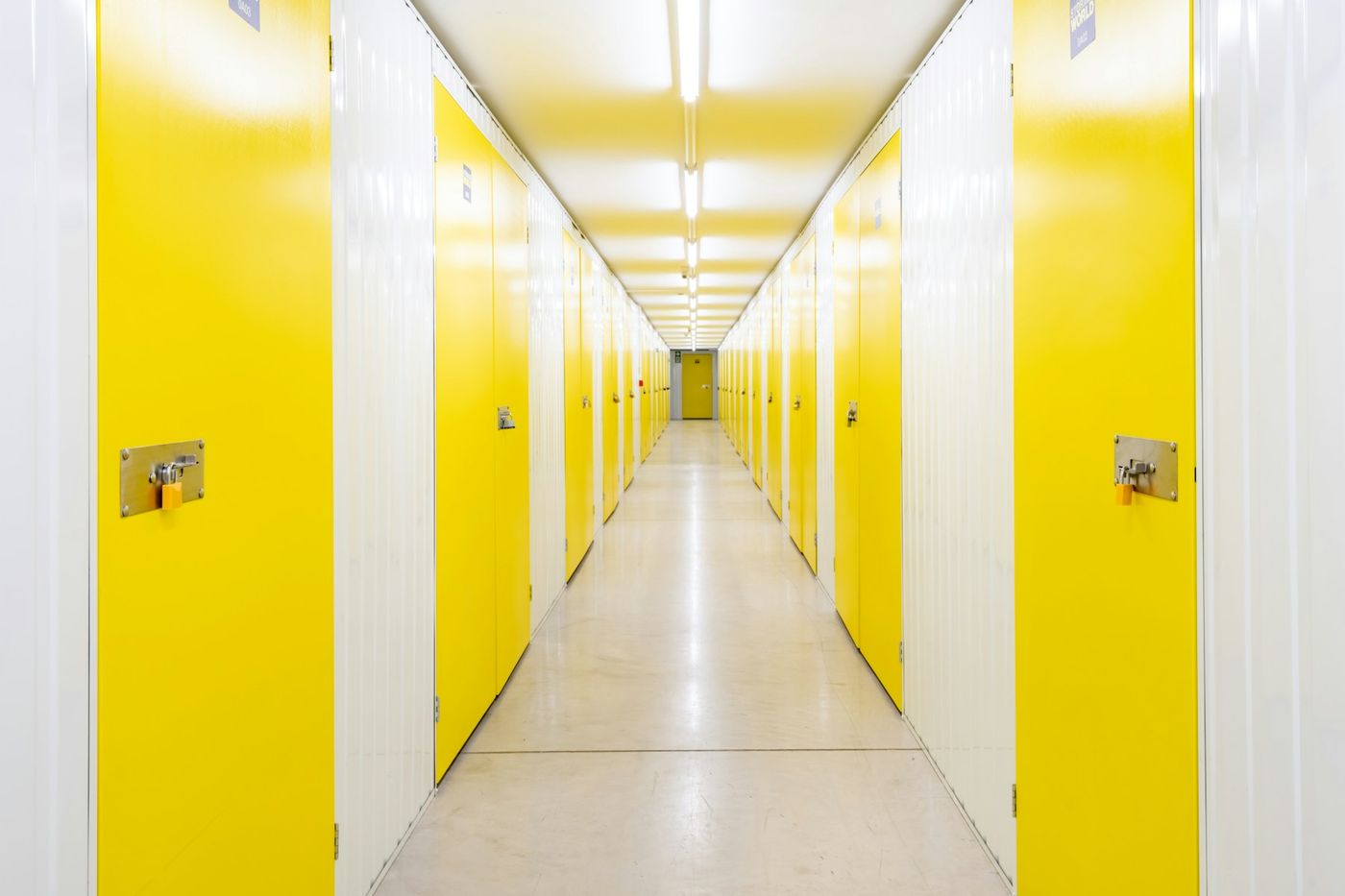 A modern, brightly lit self-storage facility corridor